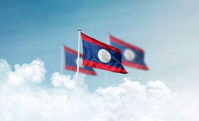 Laos national flags with mast waving in beautiful clouds. Laos flag for Republic Day and Independence Day.