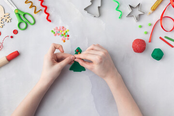 Play dough and Christmas decorations. Little child hands creating Christmas crafts. Holiday Art Activity for Kids. Sensory play for toddlers.