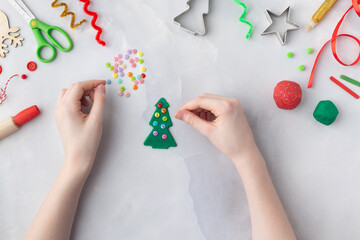 Play dough and Christmas decorations. Little child hands creating Christmas crafts. Holiday Art Activity for Kids. Sensory play for toddlers.