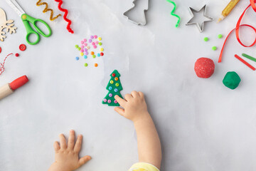 Play dough and Christmas decorations. Little child hands creating Christmas crafts. Holiday Art Activity for Kids. Sensory play for toddlers.