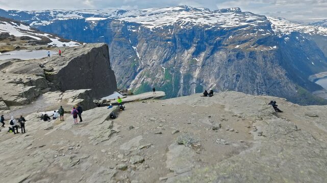 Rocky cliff edge near Trolltunga overlooking Ringedalsvatnet in Norway. Steep fjord walls and deep blue water define the dramatic landscape.