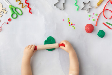 Play dough and Christmas decorations. Little child hands creating Christmas crafts. Holiday Art Activity for Kids. Sensory play for toddlers.