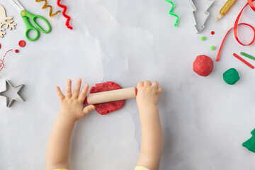 Play dough and Christmas decorations. Little child hands creating Christmas crafts. Holiday Art Activity for Kids. Sensory play for toddlers.