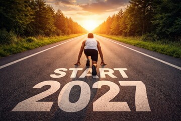 Athlete crouched at the starting line on an empty sunrise road with painted START 2027, symbolizing new beginnings, goals, and future ambition