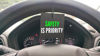 Car steering wheel with the words Safety is priority. requiring focus, adherence to rules, and responsible habits like avoiding distractions phones, wearing seatbelts, obeying speed limits