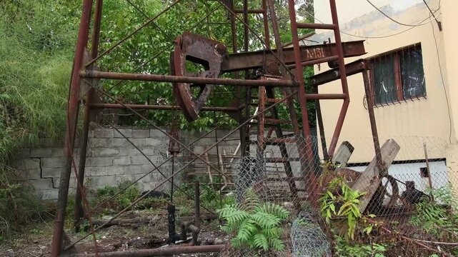 Verrostete &Ouml;lpumpe neben Wohnhaus in Ku&ccedil;ov&euml;, Ku&ccedil;ov&euml;, Bezirk Berat, Albanien
