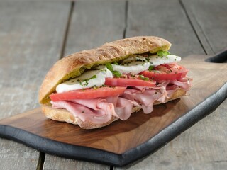 Savor a delicious sandwich featuring layers of fresh mozzarella, creamy burrata, juicy tomatoes,...