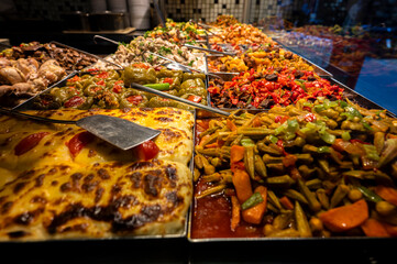 Assortment of traditional Turkish dishes in metal trays at a local self-service restaurant