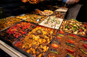Assortment of traditional Turkish dishes in metal trays at a local self-service restaurant
