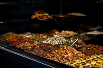 Assortment of traditional Turkish dishes in metal trays at a local self-service restaurant