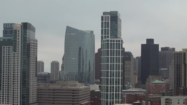 Boston, United States - 24 December 2025: Aerial view of tall buildings, including the iconic State Street building, stand in stark contrast against a cloudy sky.