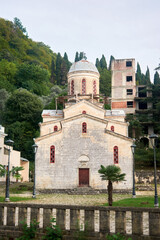 Old brick temple stands against green trees where nature frames historical architecture in vibrant contrast.