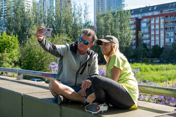 Cheerful middle aged couple taking a selfie with a smartphone after an outdoor workout