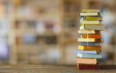 Stack of books with blurred bookshelf background. Education,back to school, knowledge is power concept. Free copy space.
