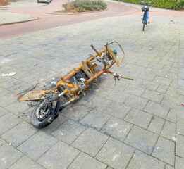 Burned Electric Scooter Wreck on Urban Sidewalk