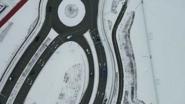 Aerial drone footage showing vehicle traffic moving through an urban area in Stavanger, Norway during winter. The scene captures roads, surrounding buildings, and typical city infrastructure under col