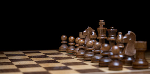 dark chess pieces on a chessboard ready for battle
