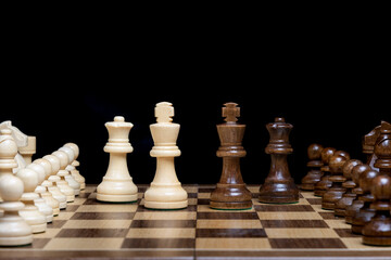 Kings and Queens meet in middle of game board backed by there support game pieces, concept of leadership and support 