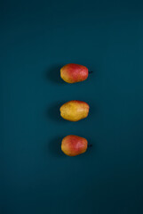 Organic ripe yellow-red pears on a dark background.