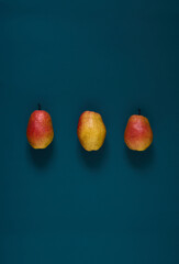 Organic ripe yellow-red pears on a dark background.