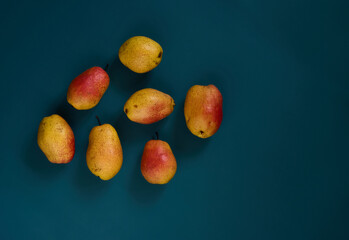 Organic ripe yellow-red pears on a dark background.