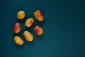 Organic ripe yellow-red pears on a dark background.