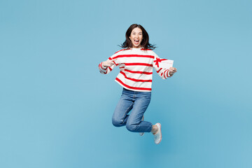 Full body young woman in red striped sweatshirt casual clothes jump high hold point on gift...