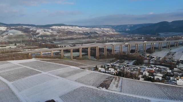 Snow covered Moselle vineyard, Viaduct Longuich, Mosel valley, winter season, bridge of highway crossing river near Trier, aerial view