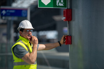 Engineer wearing safety unifrom and helmet under checking fire alarm emergency system in industry...