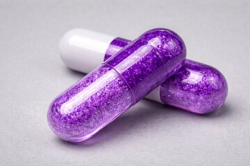 Purple capsule supplements isolated on neutral background