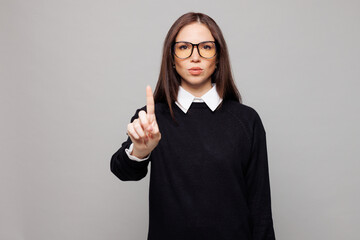 Young employee business woman corporate lawyer wears black sweater shirt work in office touch something like push click on button, point at floating virtual screen isolated on plain grey background.