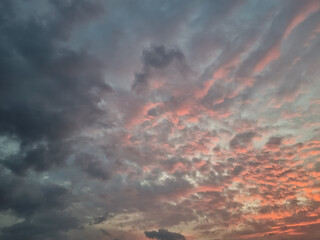 Dramatic sunset sky with textured clouds glowing in soft orange and pink evening light
