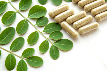 Moringa leaves with natural medicinal pills arranged neatly
