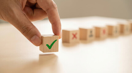 Hand places a marked cube in a row of wooden blocks on a white surface, creating a visual representation of selection