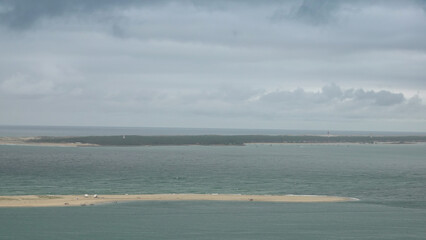 Obraz premium Vue panoramique sur le Banc d'Arguin depuis la Dune du Pilat sous un ciel d'orage menaçant, Bassin d'Arcachon.