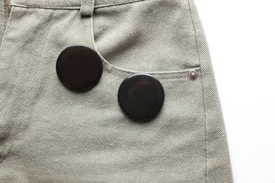 Black pin button tags on jeans close up