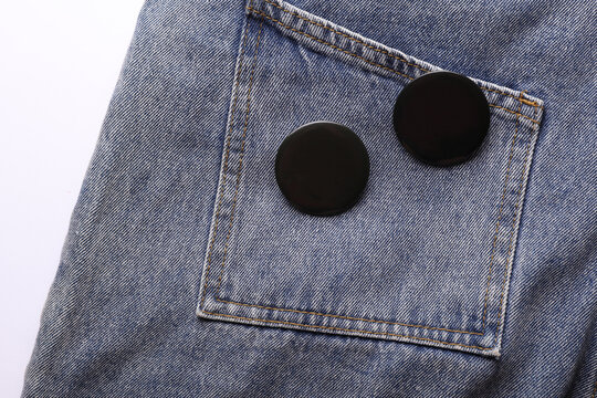 Black pin button tags on jeans close up