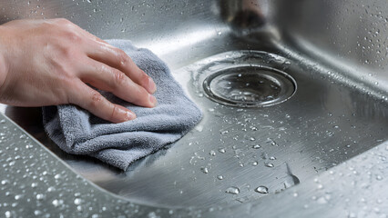Sink polishing process highlighting reflective metal surfaces and professional bathroom cleaning standards