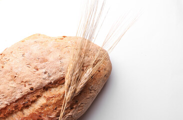 Appetizing grain bread with wheat ears on a white background
