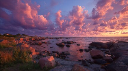 Vibrant sunset over rocky shoreline with dramatic cloudscape.