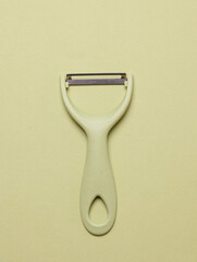 Kitchen peeler knife for peeling vegetable skins on green background