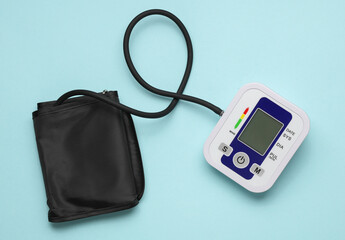 Electronic medical tonometer for measuring blood pressure on a blue background. Top view