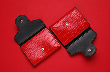 Red crocodile leather wallets on red background.