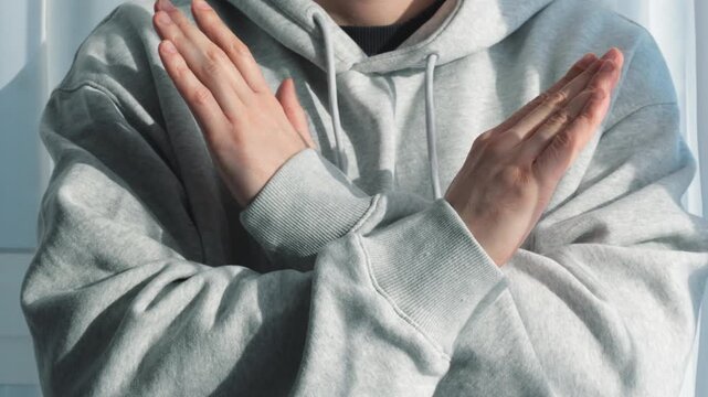 Arm-crossing gesture.
Refusal and rejection.
A person makes a gesture of refusal and rejection with their hands.