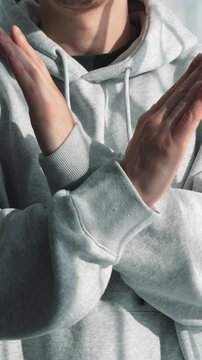 A man in gray clothes protests and crosses his arms.
A sign of rejection and non-acceptance.
A STOP gesture.
A man says no with gestures.
Crossed arms, negativity, and rejection.