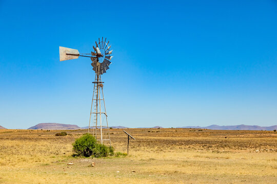 Windmill wind pump borehole in arid landscape