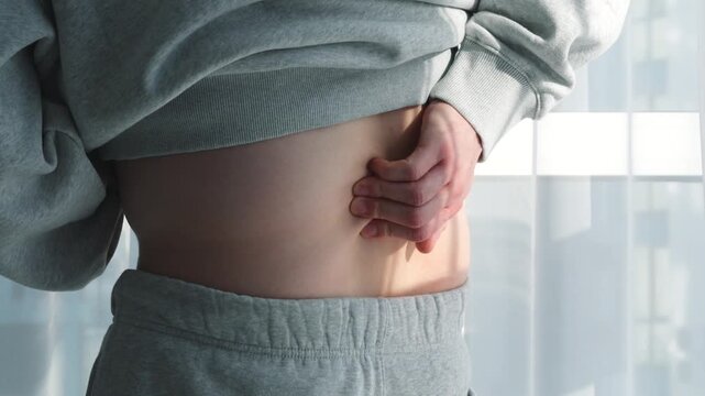 A man in a gray sports suit with a herniated disc in his back.
Back muscle strain.
Lumbar massage.
