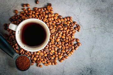 Coffee cup with coffee beans and ground coffee on gray background, Americano cup aromatic top view
