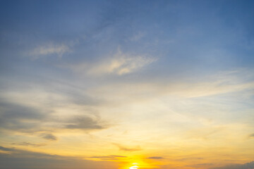 Obraz premium Golden Sunset Sky with Soft Altostratus Clouds Background,Beautiful panoramic view of the evening sky during sunset, featuring a vibrant gradient of blue and golden yellow hues with soft,