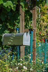 Briefkasten am gr&uuml;nen Gartenzaun
